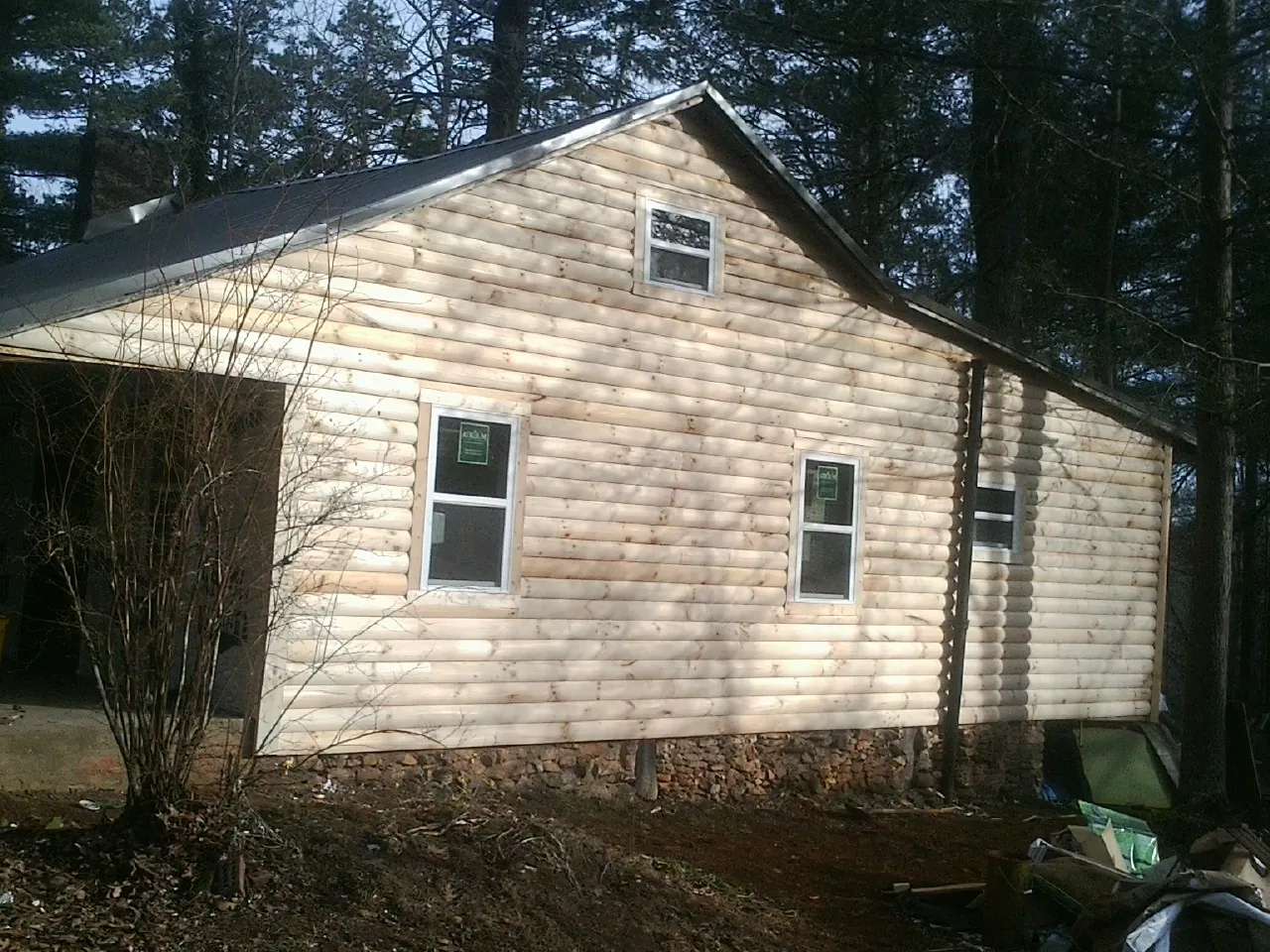 New log siding and dark metal roofing on a gable end in Broomes Island