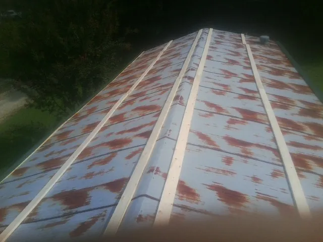 Rusted metal roof panels with new wood purlins before replacement — Storm Damage Roof Repair in Broomes Island by Roofing Brothers